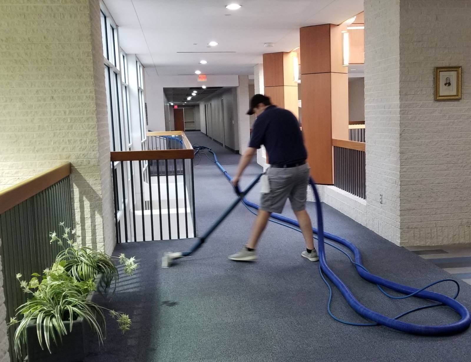 Mighty Clean professional cleaning carpeted area in commercial hallway